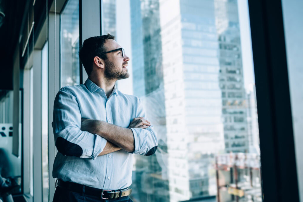 Contemplative Male Entrepreneur With Crossed Hands Standing Near